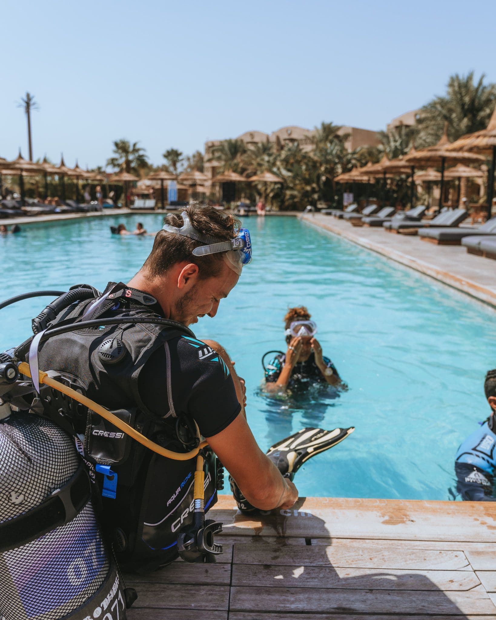 Diver preparing scuba equipment beside the training pool
