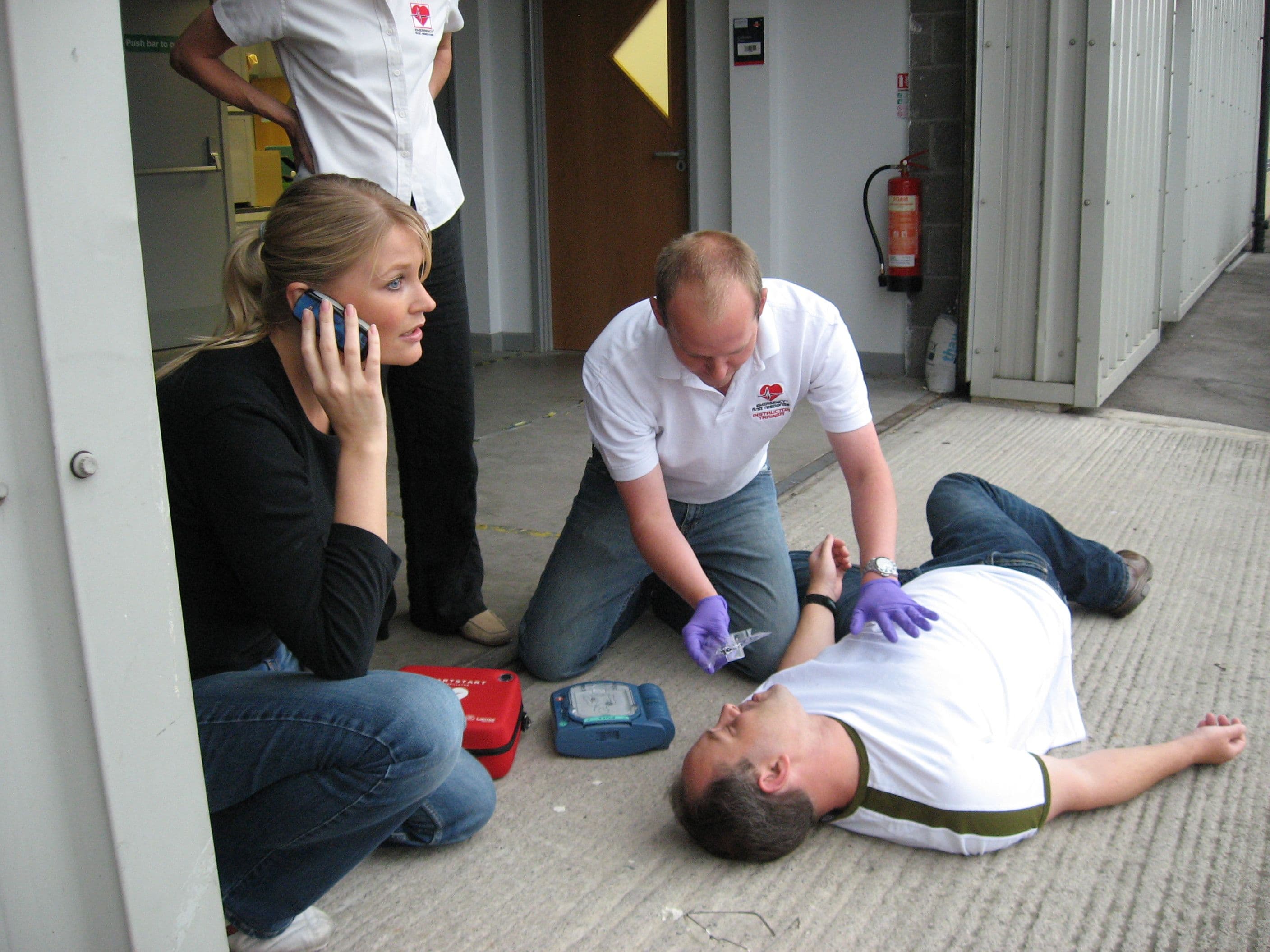 First aid team practicing emergency response with an AED
