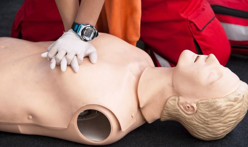 Participant practicing CPR on a first-aid training manikin
